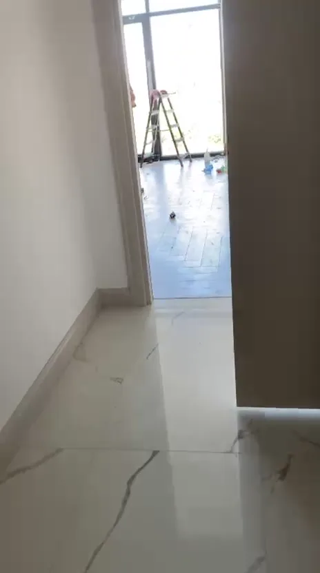 Temizlik sonrası mermer zeminli koridor ve açık kapıdan görünen oda